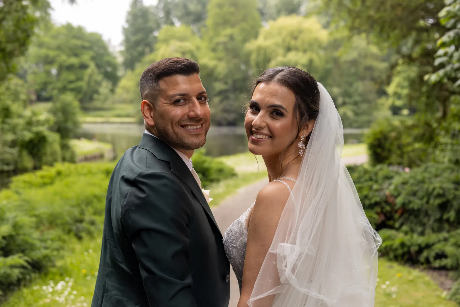 Alyssa en Menderes kijken lachend over hun schouder in het park
