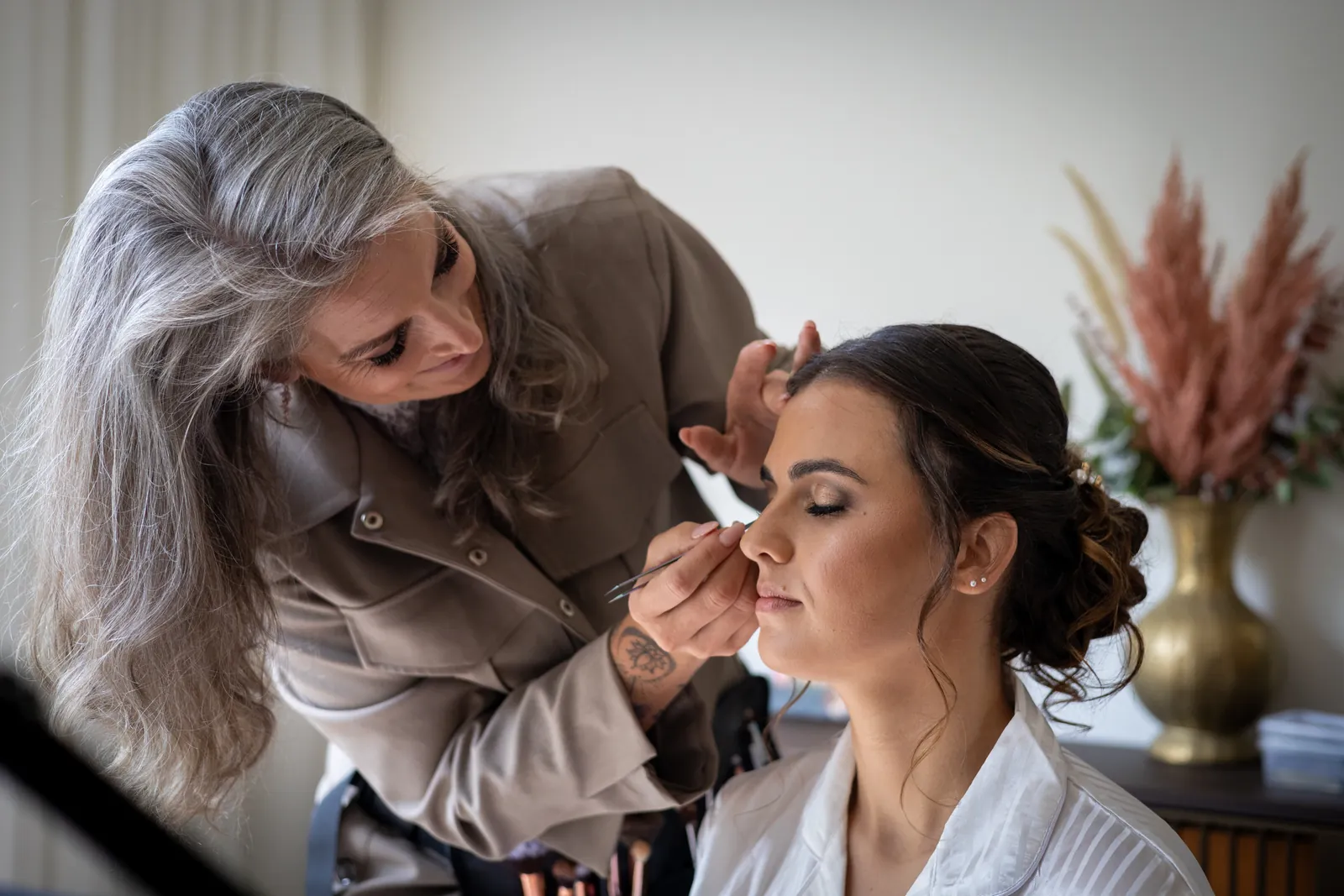 De visagiste brengt de make-up aan bij Alyssa