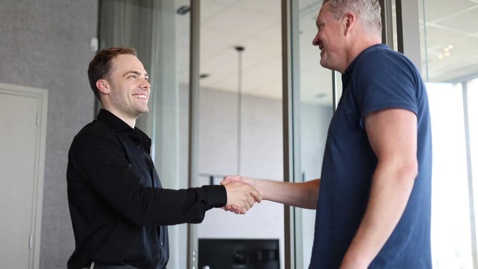 Julien van Daasign en de CEO van Groupwise geven elkaar een hand