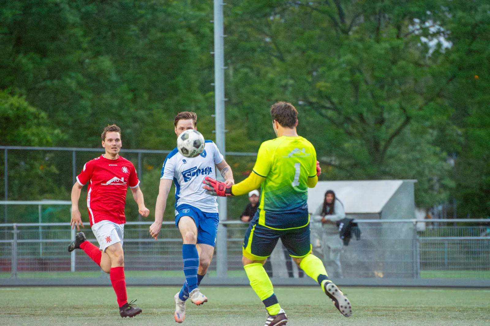 Speler van CVV Zwervers kopt de bal terwijl de keeper uitkomt in de kampioenswedstrijd